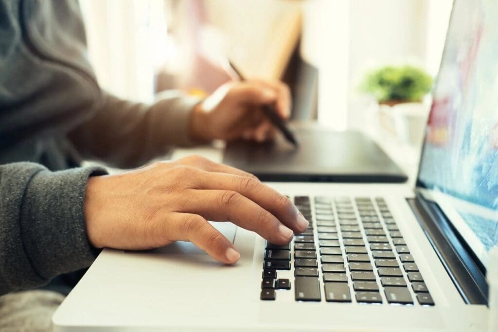 A person typing on a laptop computer.