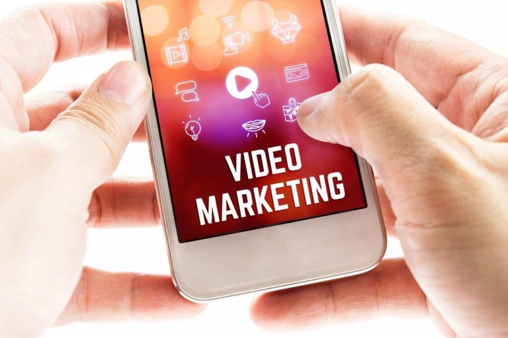 A person is holding their phone with the words video marketing on it.